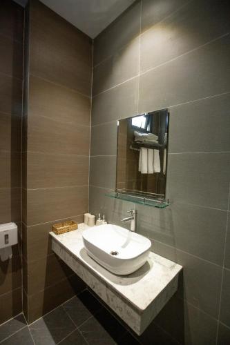 a bathroom with a sink and a mirror at Torino Hotel Dalat in Da Lat