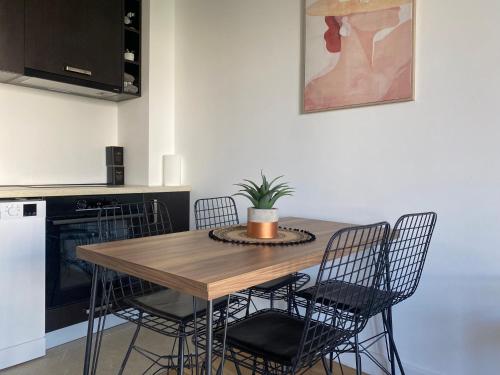 a dining room table with chairs and a potted plant at Onebedroom apartment with a pool and jacuzzy in Budva