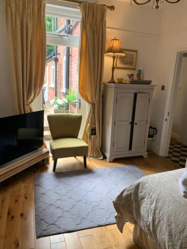 a bedroom with a bed and a chair and a window at Albany house in Birmingham