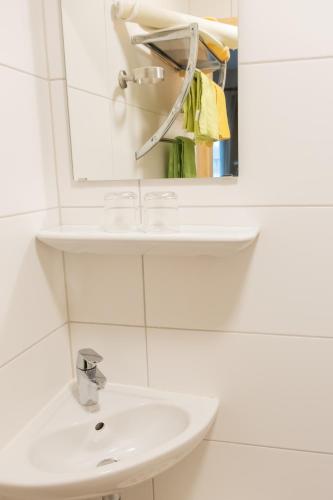 a white bathroom with a sink and a mirror at Haus Alpenrose in Obertraun