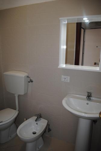 a bathroom with a toilet and a sink and a mirror at Enjoy Trani in Trani
