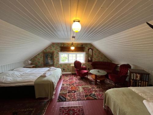 a attic bedroom with two beds and a table and chairs at Villa Wäring Husrum & Frukost in Varberg