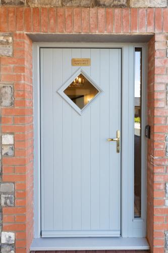 a white door in a brick building with a sign on it at Bective Stud Apartments in Navan