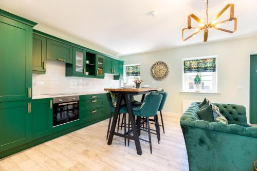 a green kitchen with a table and a couch at Bective Stud Apartments in Navan