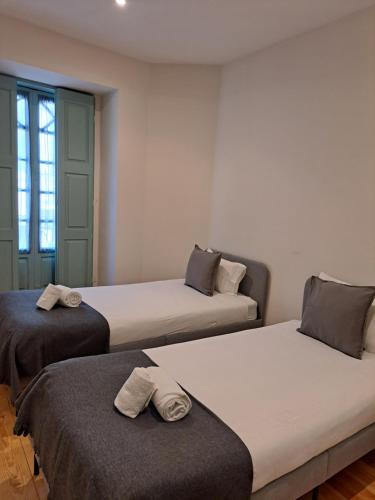 una camera con due letti con asciugamani di Near River 63 a Vila Nova de Gaia