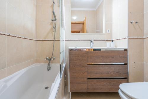 a bathroom with a tub and a sink and a toilet at The Sunset 1 Bed Flat short walk Armação beach in Armação de Pêra