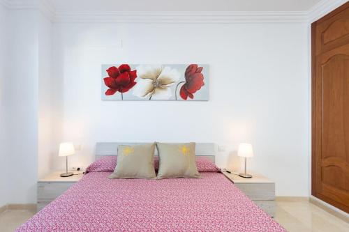 1 dormitorio con 1 cama rosa y 2 lámparas en Alojamiento acogedor y tranquilo en La Orotava