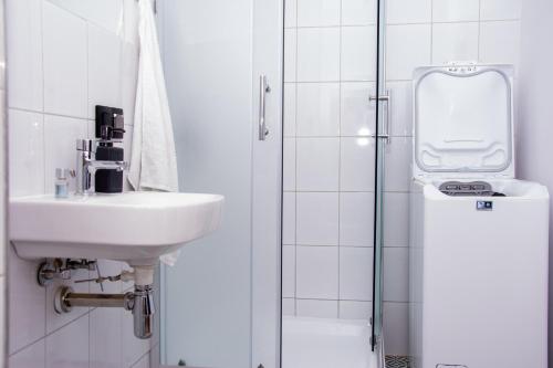 biała łazienka z umywalką i prysznicem w obiekcie Kalinówka -dom wakacyjny w Łagowie