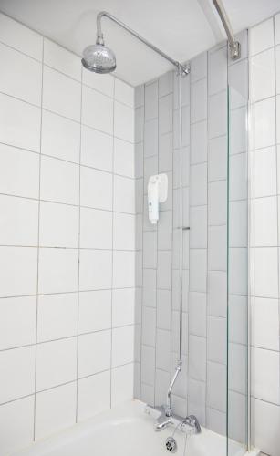 a shower with a glass door in a bathroom at Charnwood Arms By Greene King Inns in Coalville