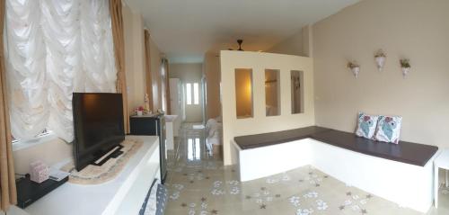 a living room with a fireplace and a television at Willkris Resort วิลล์คริส รีสอร์ท in Bang Sare