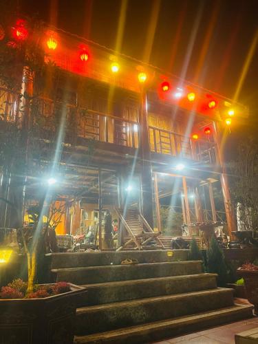 een gebouw met 's nachts een trap ervoor bij Nhà Gỗ Homestay in Blao Srê