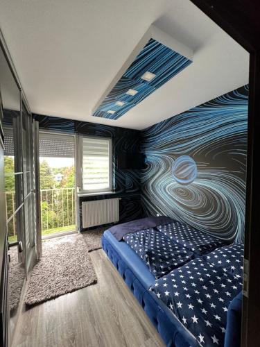 a bedroom with a blue and white wall at Gina Apartman in Debrecen
