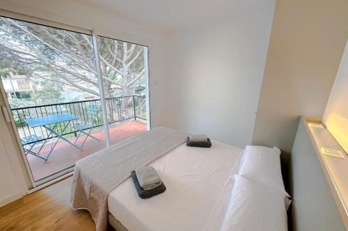 een slaapkamer met een bed en een groot raam bij T2F - Best place in Cala-Montgo beach apartment with 2 Beds, Air Conditioning and private Parking in L'Escala