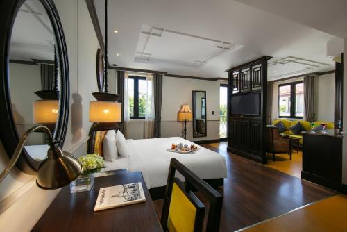 Silkian Hoian Boutique Hotel & Spa في هوي ان: غرفة في الفندق مع سرير وغرفة طعام