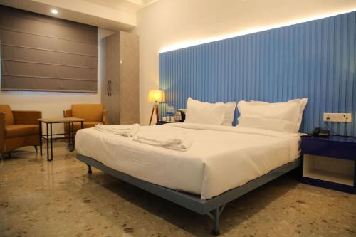 a bedroom with a large bed with a blue wall at Hotel Elite 29 Golf Course Road in Gurgaon