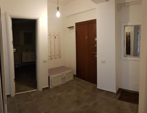 an empty room with a door and a bench in it at Seawave Beach Apartament in Constanţa