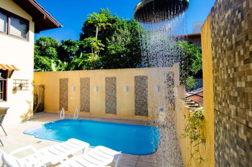 a swimming pool with a water fountain at Casa com Piscina para 12 hóspedes, 7 minutos da Praia no Campeche HY3097 in Florianópolis