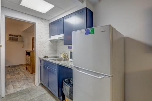 a kitchen with blue cabinets and a white refrigerator at Le Voyageur - a Red Collection Hotel in Wildwood