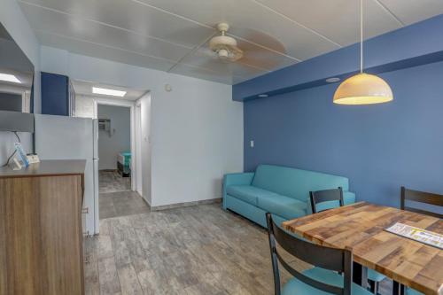 a living room with a table and a blue couch at Le Voyageur - a Red Collection Hotel in Wildwood