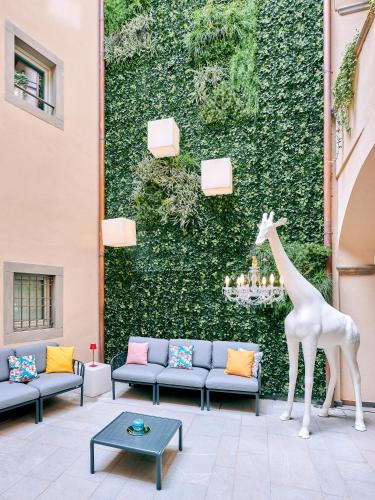 a statue of a giraffe standing in front of a wall at REGO APARTMENTS - Boutique Aparthotel with some off-site apartments in a Charming Historic District close to Upper Town in Bergamo
