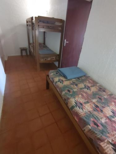 um pequeno quarto com uma cama e uma cadeira em Bienvenue en Transition 55 - Les Gardettes em Najac