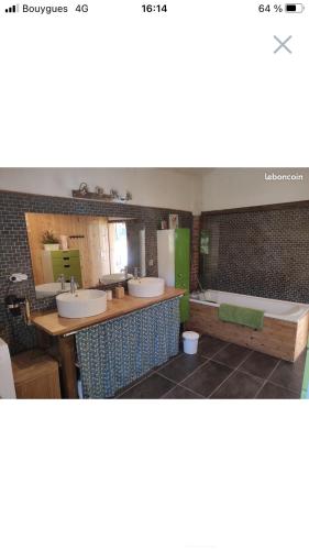 une salle de bain avec deux lavabos et une baignoire dans l'établissement Belle landaise avec piscine, à Soustons