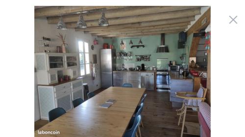 Il comprend une cuisine avec une grande table en bois et un comptoir. dans l'établissement Belle landaise avec piscine, à Soustons