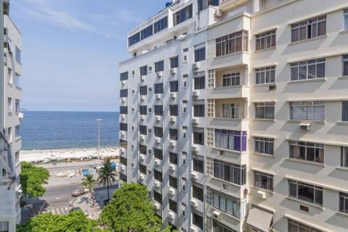 - un grand bâtiment blanc à côté d'une plage dans l'établissement Rio Habitat Almirante, à Rio de Janeiro