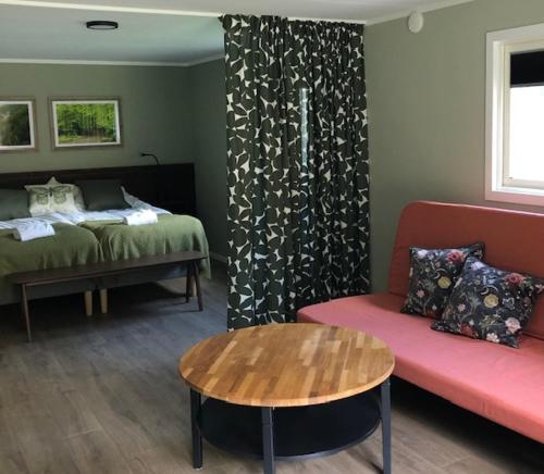 um quarto com uma cama, um sofá e uma mesa em Söderåsens Skafferi - Logi em Ljungbyhed