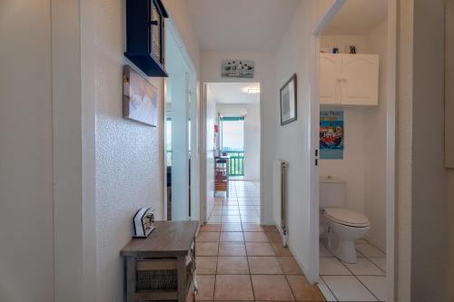 a bathroom with a toilet and a hallway at Atlantic Selection - Au calme, vue Océan avec balcon & parking in Ciboure