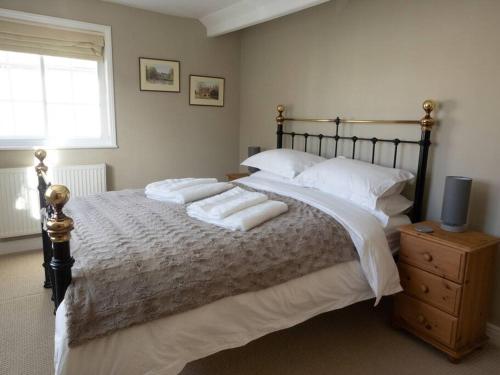 um quarto com uma cama grande com duas almofadas em The Old Reading Rooms Linton em Linton