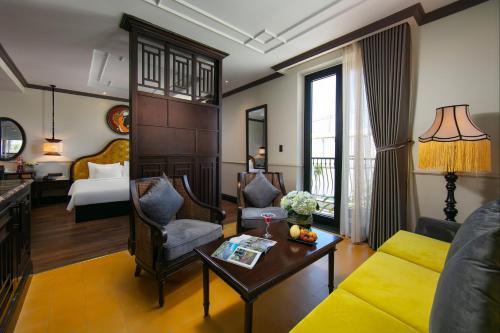 Silkian Hoian Boutique Hotel & Spa في هوي ان: غرفة معيشة مع أريكة وسرير