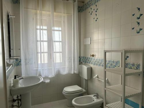een witte badkamer met een toilet en een wastafel bij Casavacanze nel blu Maestrale in Isola delle Femmine