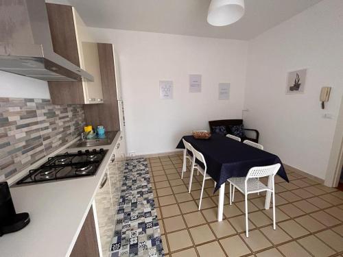 a kitchen with a table and a stove top oven at Casavacanze nel blu Maestrale in Isola delle Femmine