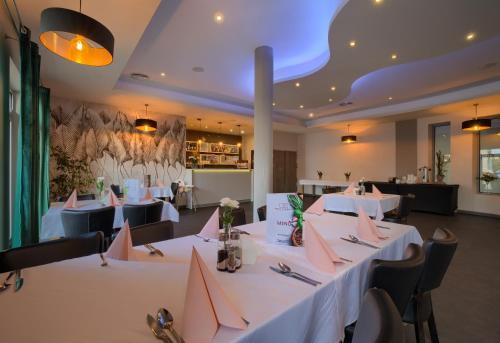 a restaurant with white tables and chairs with pink napkins at Nova Stodola in Kłomnice