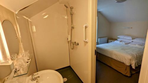 a bathroom with a shower and a toilet and a bed at Cober Hill in Scarborough