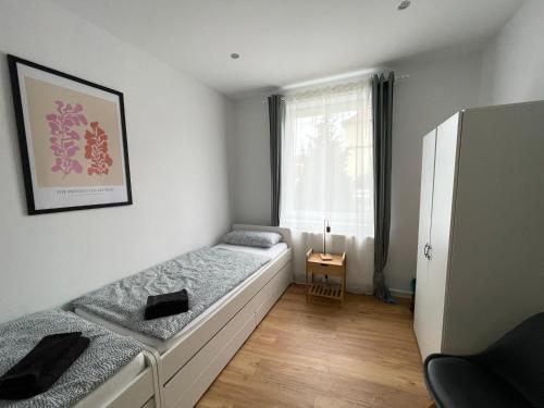 ein kleines Schlafzimmer mit 2 Betten und einem Fenster in der Unterkunft 70qm - 3 rooms - free parking - city - MalliBase Apartments in Hannover