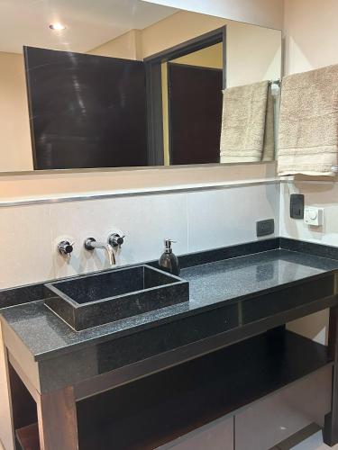 a bathroom with a black sink and a mirror at Comfortable Modern Apartment in Buenos Aires