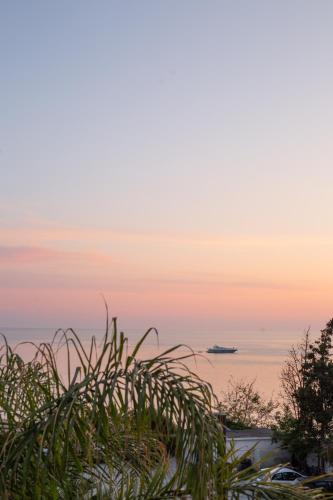 a boat in the ocean at sunset at White Hill Hotel, SPA & Conferences in Durrës