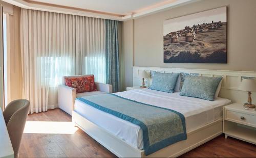 a hotel room with a bed and a window at Meydani Butik Hotel in Gokceada Town