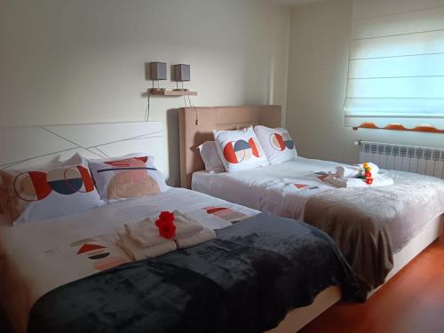 two beds sitting next to each other in a bedroom at Cantinho da Vagueira - Praia in Praia da Vagueira