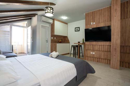 a bedroom with a large bed and a flat screen tv at Residence Ellena in Zadar
