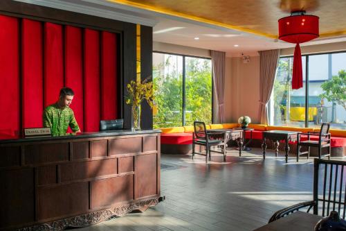 会安Silkian Hoian Boutique Hotel & Spa的站在餐厅柜台上的人