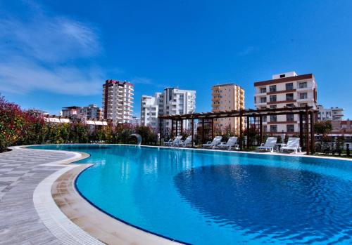 a large swimming pool with a city in the background at Upart Home in Mersin