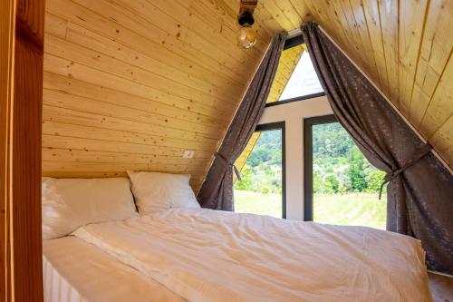 a bed in a wooden room with a window at Ungefug A-Frame Sighisoara in Sighişoara