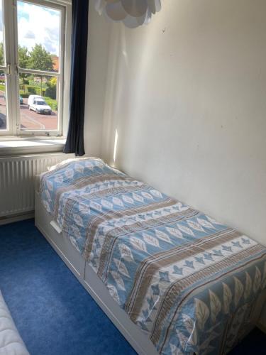 ein kleines Bett in einem Zimmer mit Fenster in der Unterkunft Sunnystay 43 in Middelburg