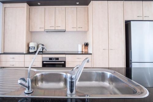 a kitchen with a stainless steel sink in a kitchen at Stones Throw To Shelly Beach, Pet Friendly! in Caloundra
