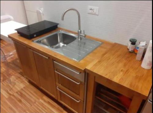 - une cuisine avec un évier et un comptoir en bois dans l'établissement La Giuggiola, à Padoue