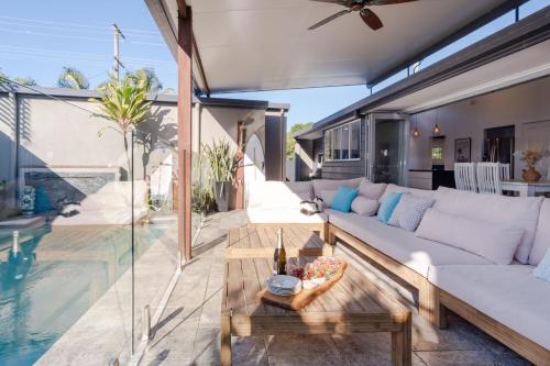 a living room with a couch and a table at Pet Friendly House Opposite Bokarina Beach in Kawana Waters