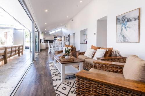 una sala de estar con un sofá y una mesa en Pet Friendly House Opposite Bokarina Beach, en Kawana Waters